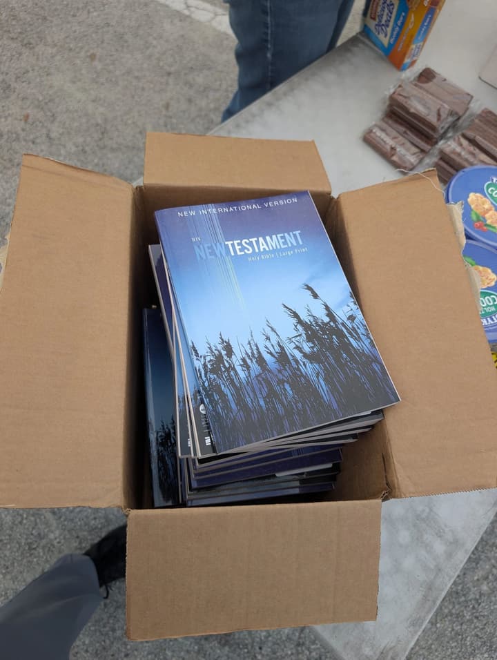 A box of large-print New Testaments set out on the serving table